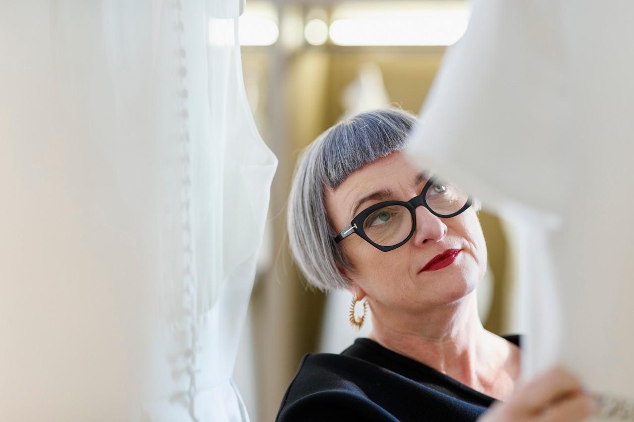 A female business owner, getting a strong portrait next to her organically made wedding dresses. / Female Focus Collection